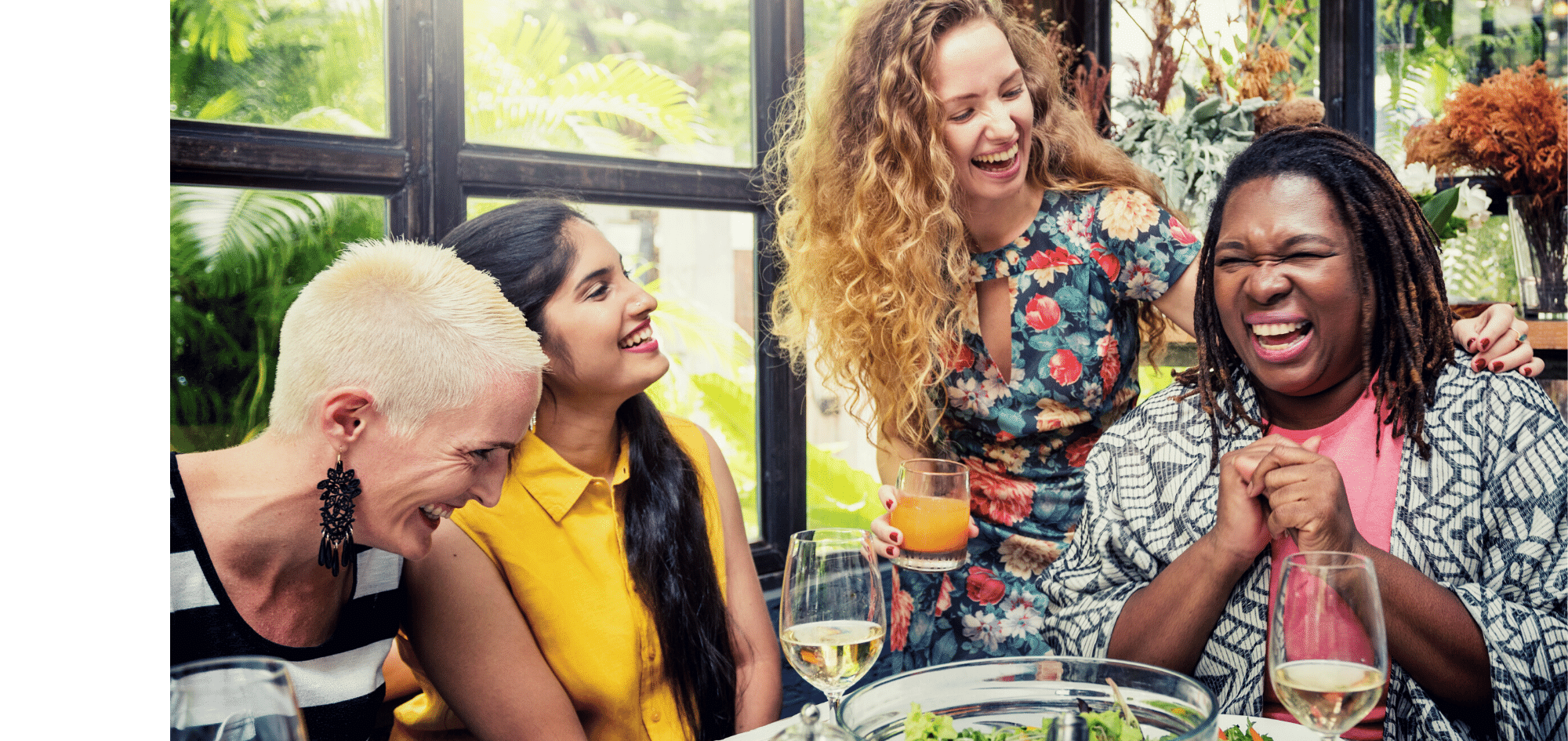 Diverse group of middle-aged women laughing over lunch